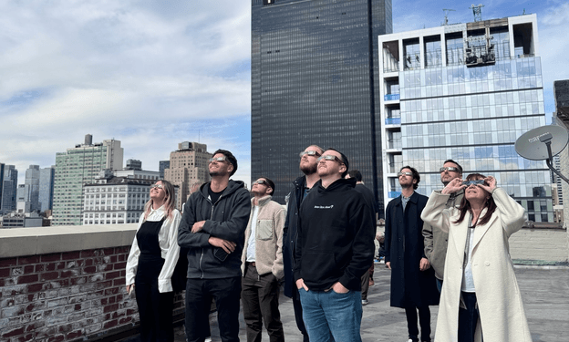 Witbe team on the New York office rooftop watching a solar eclipse together.